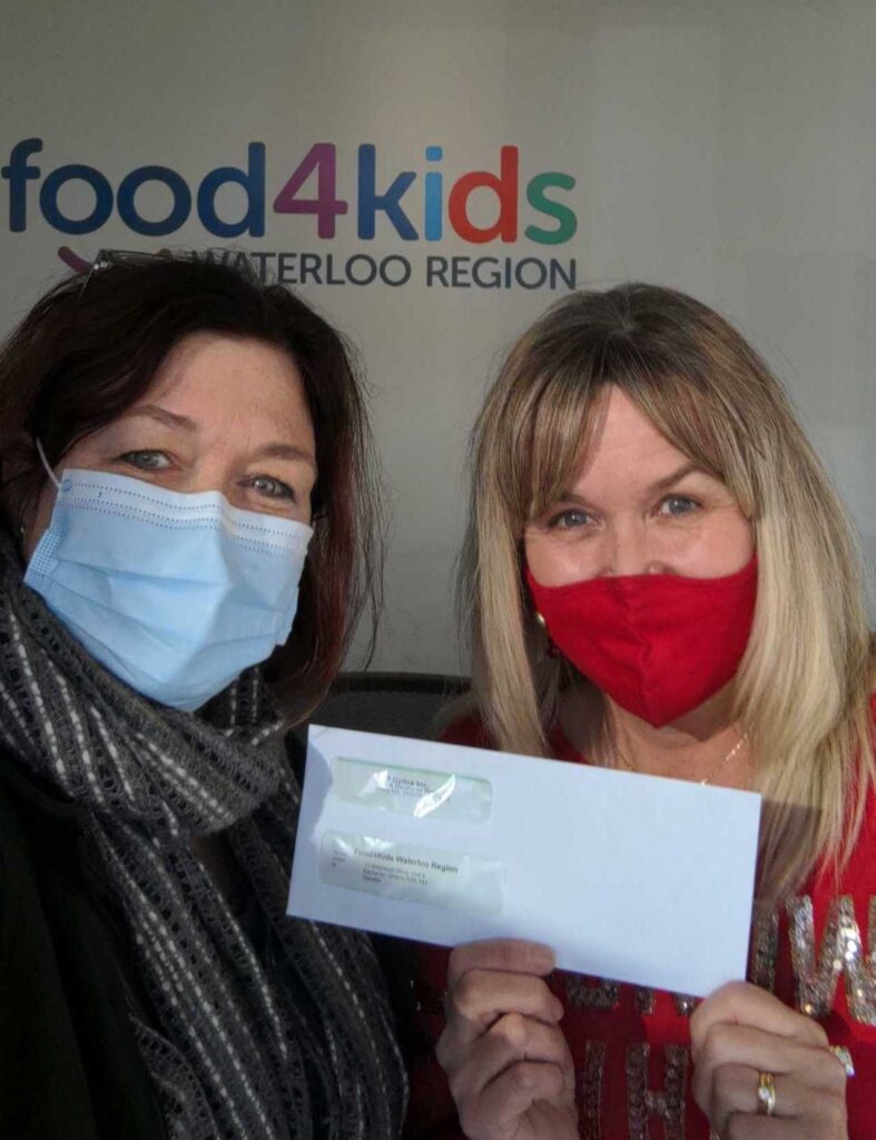 Two PPO employees showing the donated cheque to Food4Kids at the Food4Kids office