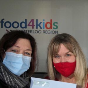 Two PPO employees showing the donated cheque to Food4Kids at the Food4Kids office