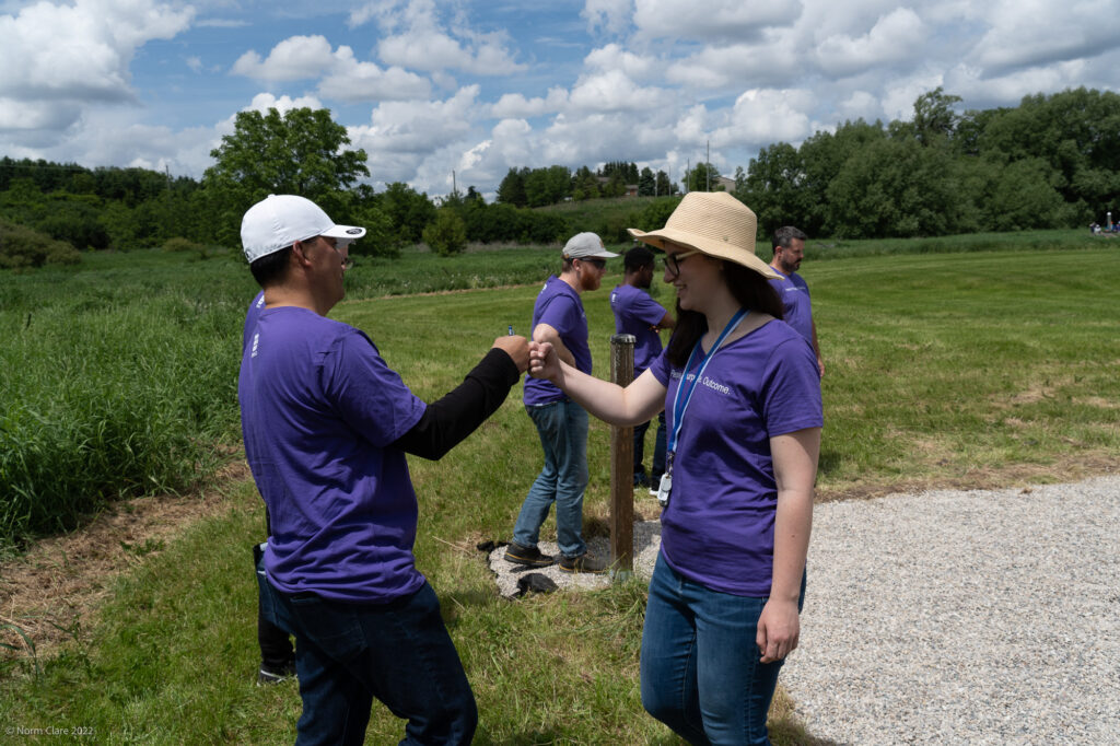 Two PPO Employees giving a fist bump in a field